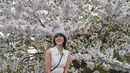 Anya Geraldine mengunggah potret dirinya dengan latar pohon sakura berwarna putih yang sedang bermekaran. [Foto: Instagram/anyageraldine]