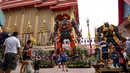 Suasana di depan kuil Buddha Wat Tha Kien yang menghadirkan patung logam raksasa yang terinspirasi oleh 'Transformers' di Nonthaburi, Thailand (18/6). Patung karya Ban Hun Lek dihadirkan untuk menarik pengunjung. (AFP Photo/Lillian Suwanrumpha)