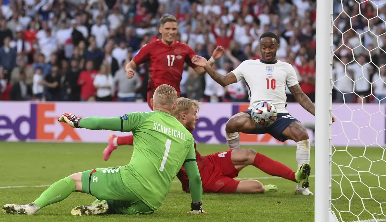 Raheem Sterling yang siap menyambut bola operan dari Bukayo Saka bersiap untuk meneruskan umpan tersebut, namun Simon Kjaer yang tepat berada disamping Sterling lebih dulu meneruskan bola tersebut ke gawangnya sendiri. (Foto: AP/Pool/Laurence Griffiths)