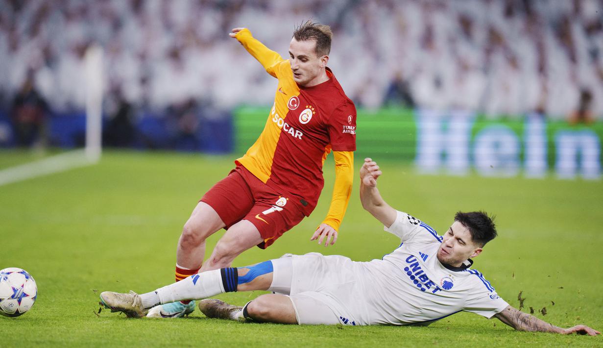 Pemain FC Copenhagen, Kevin Diks, berebut bola dengan pemain Galatasaray, Kerem Akturkoglu, pada laga Liga Champions (12/12/2023). Kevin Diks menjadi buah bibir karena mampu mengantarkan Copenhagen lolos ke babak 16 besar Liga Champions. (AFP/Liselotte Sabroe)