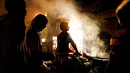 Sejumlah buruh makan malam di sebuah warung makanan pinggir jalan di kawasan tua New Delhi, India (6/3). Sebelumnya India sempat menjadi negara dengan pertumbuhan ekonomi paling pesat di dunia. (AFP Photo/Chandan Khanna)