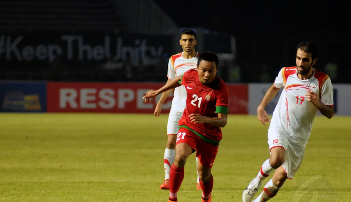 Gelandang timnas Indonesia, M Ridwan (tengah) menghindari kawalan Ahmad Deeb (Suriah - kanan) saat berlaga di Stadion GBK Jakarta, (15/11/2014). Timnas Indonesia kalah 0-2 dari Suriah. (Liputan6.com/Helmi Fithriansyah)