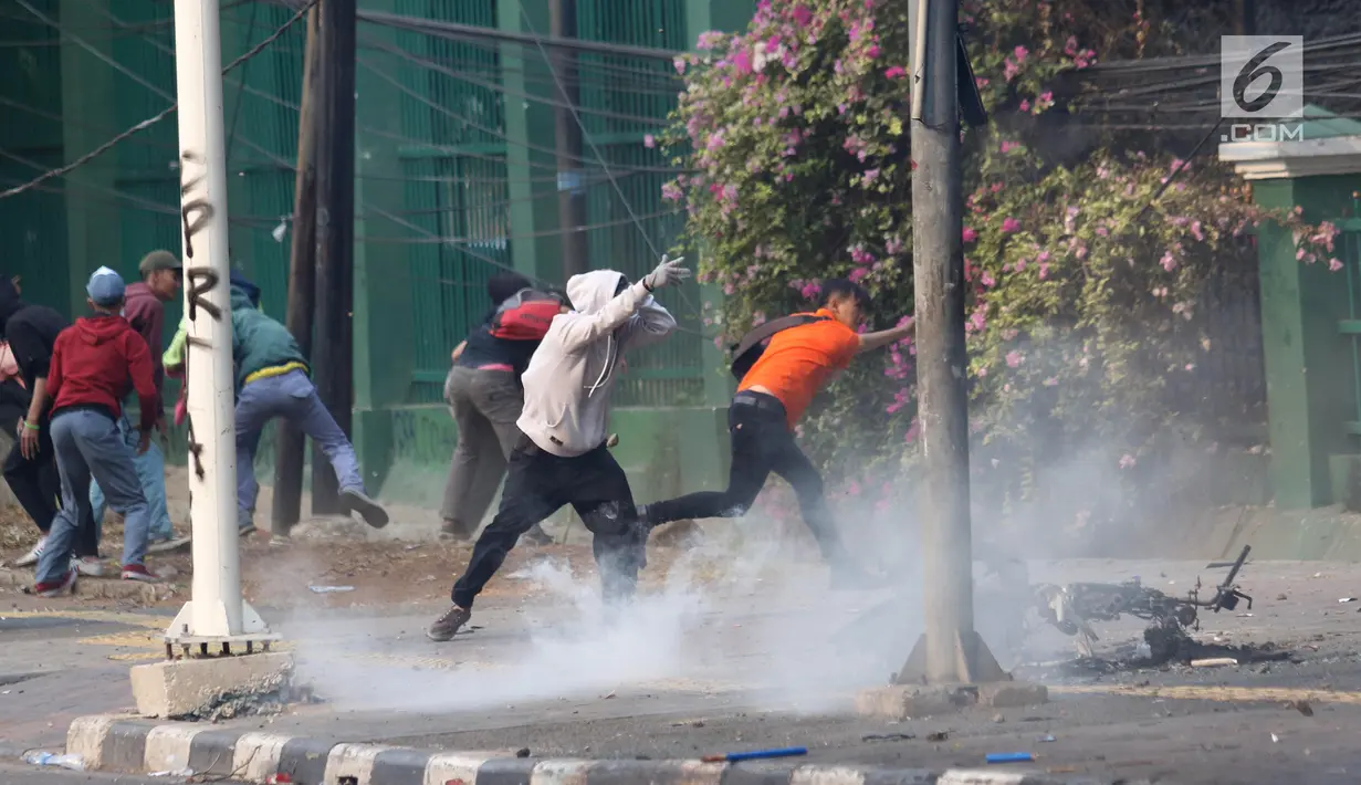 Pelajar melempari Gedung DPR dengan batu saat berunjuk rasa di Palmerah, Jakarta, Rabu (25/9/2019). Pihak kepolisian menembakan gas air mata untuk memukul mundur pelajar. (Liputan6.com/Angga Yuniar)