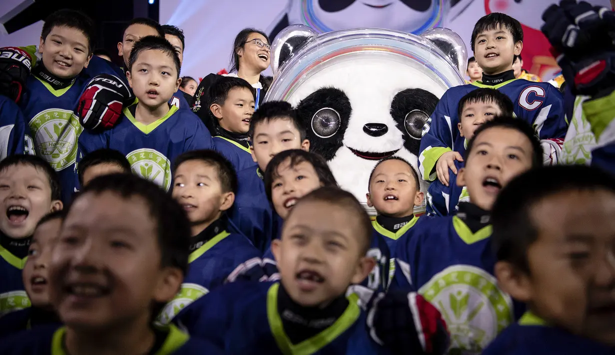 Anak-anak foto bersama dengan Bing Dwen Dwen, Maskot Olimpiade Musim Dingin Beijing 2022 di Arena Hoki Es Shougang (17/9/2019). Kristal es yang mengelilingi “Bing Dwen Dwen” menceritakan tentang fitur olahraga musim dingin. (AFP Photo/Noel Celis)