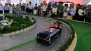 Pengunjung melihat sebuah model bus yang mengangkangi jalan di sebuah pameran di Beijing, Cina, (19/5). Bus ini bergerak menggunakan listrik, lebih hemat energi karena membawa 1.200 orang setara 40 bus konvensional. (REUTERS/Hu Qingming)