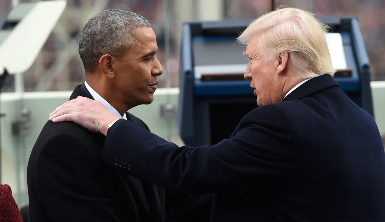 Barack Obama menyalami Donald Trump jelang penyampaian pidato pertama Trump sebagai Presiden AS di Capitol Hill, Washington DC, AS, Jumat (20/1). Dikabarkan, Trump sendiri yang menulis dan menyusun pidato pelantikannya. (AFP Photo)