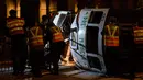 Regu penolong berusaha mengevakuasi trem double-decker yang terbalik di jalan utama di Hong Kong, Kamis (6/4). Kecelakaan yang terjadi tengah malam waktu setempat itu mengakibatkan 11 orang mengalami luka-luka. (ANTHONY WALLACE/AFP)