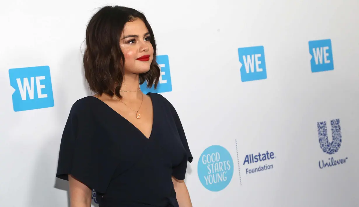 Penyanyi Selena Gomez berpose saat menghadiri WE Day California di The Forum di Inglewood, California (19/4). Hak sepatu Selena Gomez berbentuk sangat unik karena terdiri dari tiga bulatan dan berbahan suede. (AFP Photo/Tommaso Boddi)