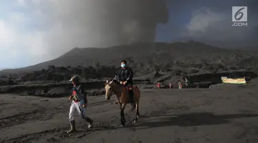 Wisatawan menunggang kuda saat gunung Bromo yang sedang mengalami erupsi di Probolinggo, Jawa Timur, Selasa (26/3/2019). Kawasan wisata Gunung Bromo masih aman dikunjungi wisatawan asalkan tidak melakukan aktivitas di area dalam radius satu kilometer dari kawah Gunung Bromo (merdeka.com/Arie Basuki)