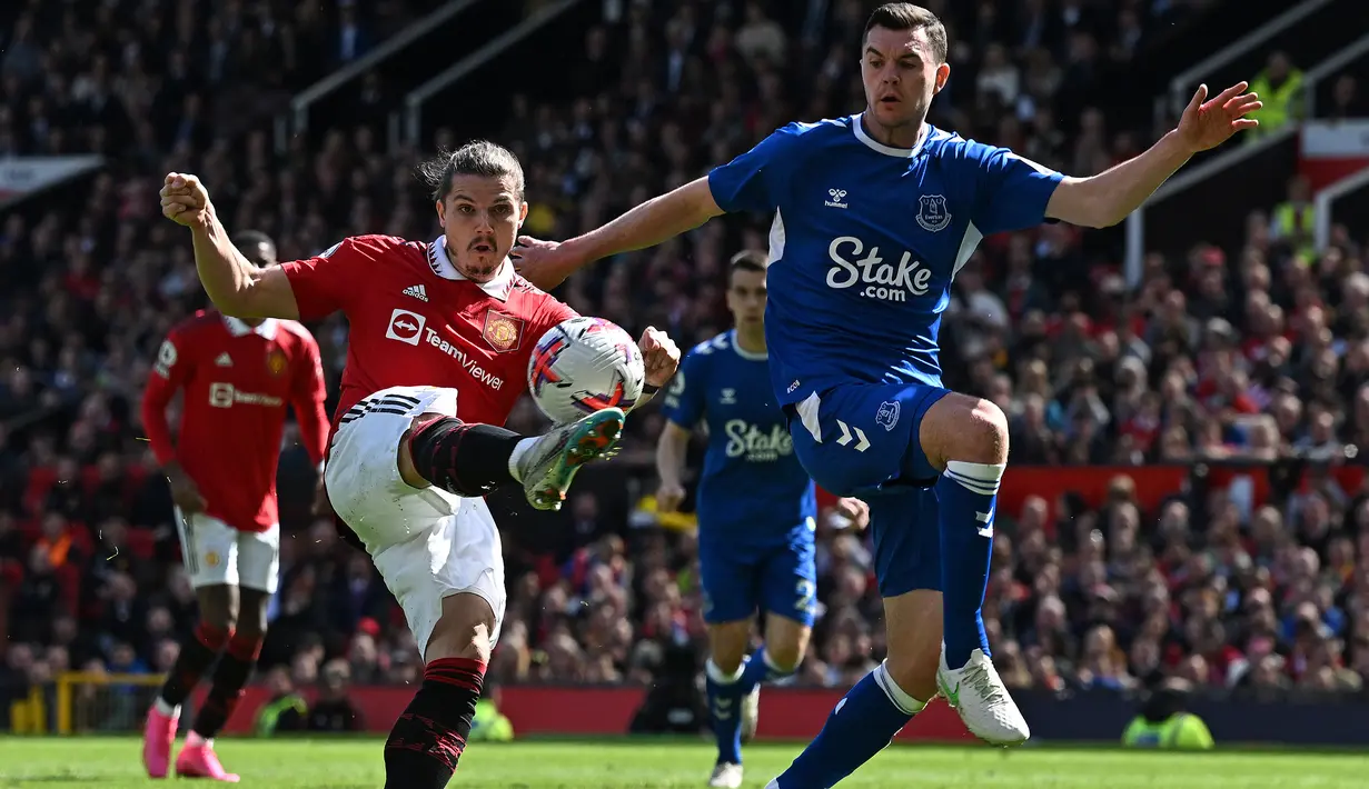 Gelandang Manchester United, Marcel Sabitzer (kiri) melepaskan tendangan di depan bek Everton, Michel Keane pada laga lanjutan pekan ke-30 Liga Inggris 2022/2023, Sabtu (8/4/2023) di Old Trafford Stadium, Manchester. (AFP/Paul Ellis)