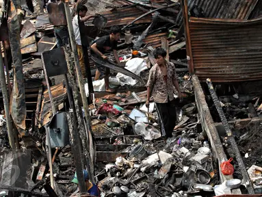 Warga mengumpulkan puing sisa kebakaran di Pasar  Inpres Tanah Abang, Jakarta, Minggu (11/10/2015). Kebakaran yang terjadi pada Minggu (11/10) dini hari tersebut menghanguskan 136 kios (Liputan6.com/Immanuel Antonius)