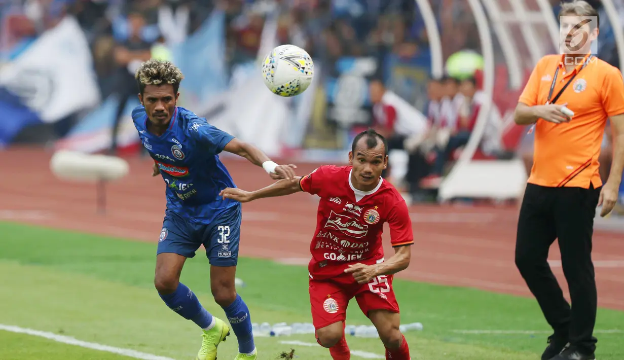 Pemain tengah Persija, Riko Simanjuntak (tengah) berebut bola dengan Gelandang Arema FC, Alvin Tuasalamony pada lanjutan Shopee Liga 1 Indonesia 2019 di Stadion Gelora Bung Karno, Jakarta, Sabtu (3/8/2019). Laga berakhir imbang 2-2. (Liputan6.com/Helmi Fithriansyah)