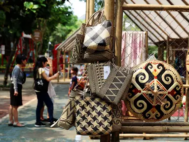 Sejumlah tas dan penutup kepala hasil kerajinan tangan dipamerkan dalam Festival Panen Raya Nusantara di Taman Menteng, Jakarta, Jumat (13/10). Festival tersebut menampilkan berbagai macam produk nusantara. (Liputan6.com/Angga Yunair)
