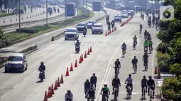 Warga berolahraga menggunakan sepeda di sepanjang Jalan Sudirman, Jakarta, Minggu (26/7/2020). Perluasan jalur sepeda sementara dilakukan sebagai dampak dari peniadaan hari bebas kendaraan bermotor (HBKB) di Jalan Sudirman-Thamrin. (Liputan6.com/Faizal Fanani)