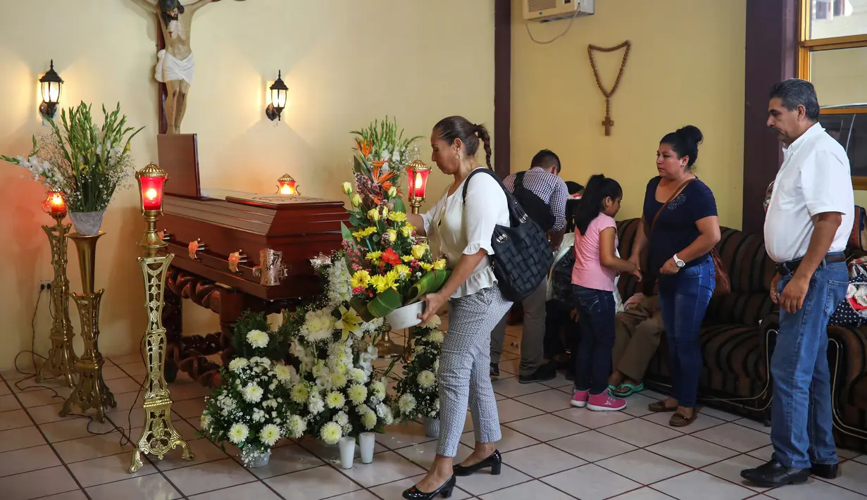 Keluarga dan kerabat memberi karangan bunga untuk jenazah Leobardo Vazquez, wartawan yang tewas di Gutierrez Zamora, Meksiko (22/3). Wartawan itu tewas di wilayah yang dipenuhi kartel narkoba. (AP/Felix Marquez)