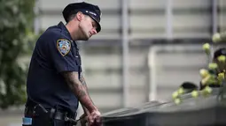 Ekspresi petugas New York City Police Department (NYPD) selama peringatan 16 tahun korban serangan 11 September di Museum dan Memorial Nasional 9/11, New York, Amerika Serikat, Senin (11/9). (Drew Angerer/Getty Images/AFP)