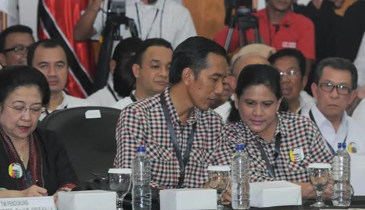 Jokowi tampak berbincang dengan istrinya yang kompak mengenakan baju kotak-kotak di dalam Gedung KPU (Liputan6.com/Herman Zakharia)