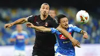 Striker AC Milan, Zlatan Ibrahimovic, berebut bola dengan  pemain Napoli, Mario Rui, pada laga Serie A di Stadion San Paolo, Minggu, (12/7/2020). Kedua tim bermain imbang 2-2. (Spada/LaPresse via AP)