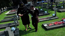 Istri almarhum Pembantu Letnan Satu Supadmo, Kasiyah (kiri) saat berjalan menuju makam suaminya di TMP Kalibata, Jakarta, Senin (10/11/2014). (Liputan6.com/Johan Tallo) 