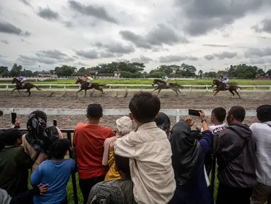 Orang-orang menonton balapan kuda dalam ajang Piala Raja Hamengku Buwono X 2025, kejuaraan balap kuda nasional tahunan yang memperebutkan trofi Sultan Hamengku Buwono X, di lintasan Sultan Agung, Bantul, Yogyakarta, pada Minggu 9 November 2025. Indonesia's Horse Racing (IHR) Piala Raja Hamengku Buwono (HB) X 2025 sukses digelar di Lapangan Pacuan Kuda Sultan Agung, DI Yogyakarta, Minggu (9/11/2025). (DEVI RAHMAN/AFP)