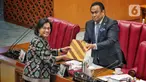 Menteri Keuangan Sri Mulyani (kiri) menyerahkan laporan pemerintah terkait RUU tentang APBN TA 2023 Wakil Ketua DPR RI Rahmat Gobel saat Rapat Paripurna di kompleks Parlemen, Jakarta, Kamis (29/9/2022). Agenda rapat paripurna kali ini adalah pembicaraan tingkat II/pengambilan keputusan atas RUU tentang APBN tahun anggaran 2023. (Liputan6.com/Angga Yuniar)