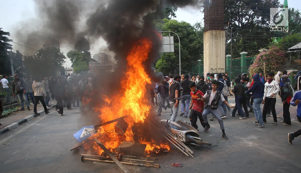 Pelajar membakar sepeda motor dan rambu lalu lintas saat berdemonstrasi di belakang Gedung DPR, Palmerah, Jakarta, Rabu (25/9/2019). Polda Metro Jaya mengamankan 200 pelajar yang berdemonstrasi. (Liputan6.com/Angga Yuniar)