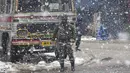 Seorang prajurit paramiliter India berjaga-jaga ketika salju turun di Srinagar, Kashmir yang dikuasai India (15/1/2020). Menurut pejabat sipil Baseer Khan, Jalur listrik rusak dan banyak jalan terkubur di bawah salju yang mempengaruhi aktivitas warga sehari-hari. (AP Photo/Dar Yasin)