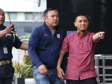 Bupati Pakpak Bharat Sumatera Utara, Remigo Yolanda Berutu (kedua kiri) digiring petugas saat tiba di Gedung KPK, Jakarta, Minggu (18/11). Remigo terkena OTT terkait dugaan penerimaan suap proyek di Dinas PUPR. (Liputan6.com/Helmi Fithriansyah)