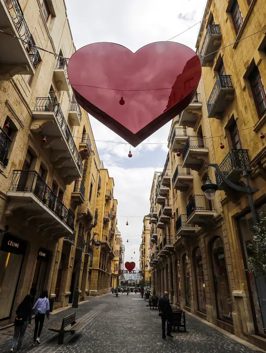 Warga beraktivitas di sebuah jalan yang di dekorasi simbol hati di pusat ibukota Lebanon, Beirut (8/2). Kota tersebut bersiap untuk merayakan Hari Valentine pada 14 Februari. (AFP Photo/Joseph Eid)