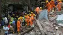 Tim penyelamat mencari korban lainnya dalam puing-puing bangunan di Mumbai, India, Selasa (25/7). Sebuah gedung penghunian lima lantai runtuh pada selasa pagi waktu setempat. (AP/Rafiq Maqbool) 