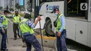 Petugas memeriksa lokasi bus Transjakarta yang menabrak separator busway di kawasan Bundaran Senayan, Jakarta, Jumat (3/12/2021). Kecelakaan mengakibatkan bagian depan bus Transjakarta rusak karena menghantam separator busway. (Liputan6.com/Faizal Fanani)