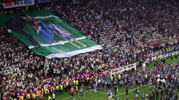 Suporter PSG membentangkan poster bergambar Luis Enrique dan mendiang putrinya, Xana setelah laga final Liga Champions 2024/2025 melawan Inter Milan di Allianz Arena, Munchen, Jerman, Minggu (01/06/2025) dini hari WIB. (AFP Kirill Kudryavtsev)