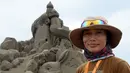 Seniman patung pasir Jepang, Yoshiko Matsugi, berpose di depan karyanya yang akan dipamerkan dalam pameran bertema Asahi Sand Sculpture di pantai Yasashigaura, Asahi, Chiba, (13/7/2014). (AFP PHOTO/Toshifumi Kitamura)