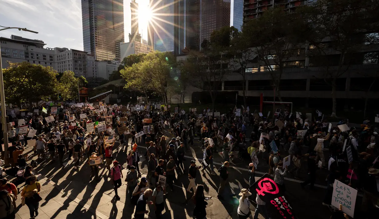 Para pengunjuk rasa membanjiri jalan-jalan di beberapa kota besar AS pada hari Sabtu untuk menentang kebijakan-kebijakan Presiden Donald Trump. (ETIENNE LAURENT/AFP)