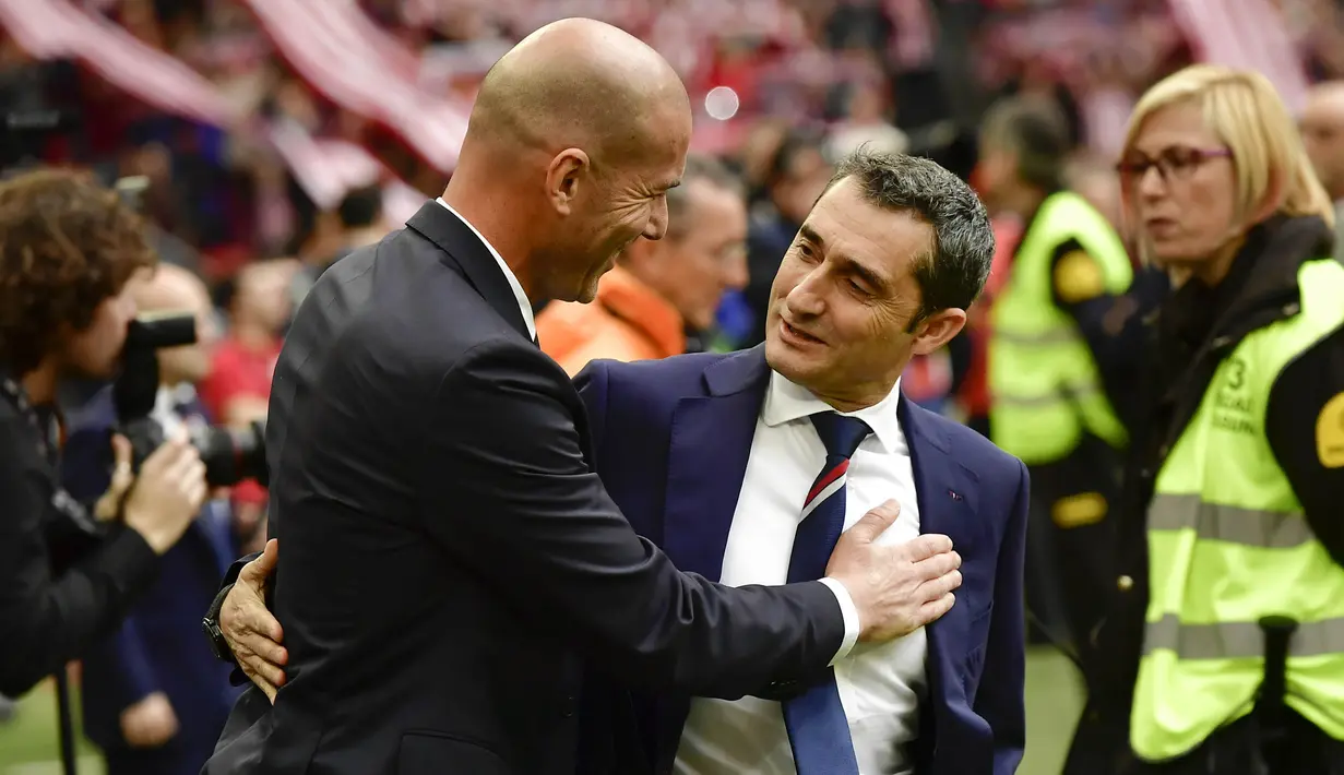Pelatih Real Madrid, Zinedine Zidane, menyapa pelatih Athletic Bilbao, Ernesto Valverde. Tambahan tiga poin membuat Real Madrid nyaman di puncak klasemen La Liga dengan nilai 65 dari 26 laga. Unggul dua poin dari Barcelona. (AP/Alvaro Barrientos)