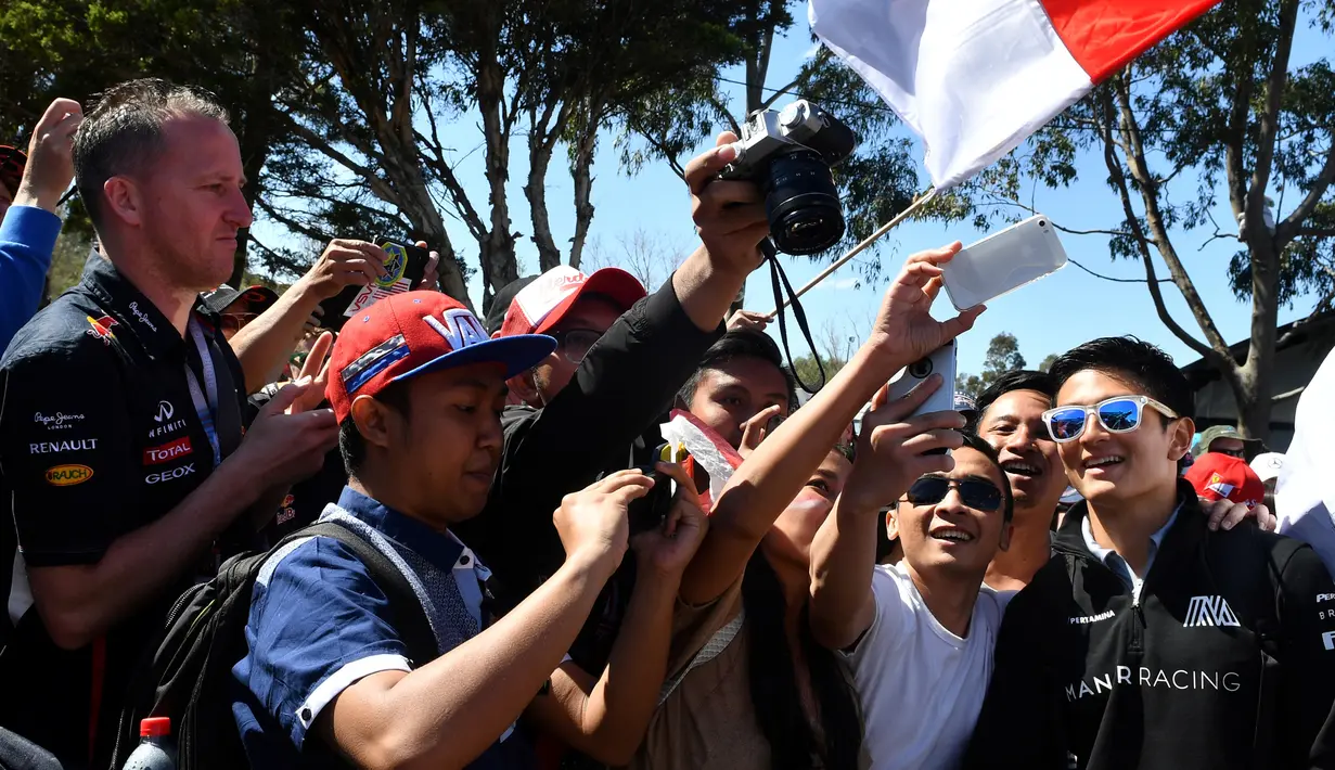 Pebalap Manor Racing asal Indonesia, Rio Haryanto, menyapa penggemar sebelum memulai balapan F1 GP Australia di Sirkuit Albert Park, Minggu (20/3/2016). (AFP/Paul Crock)