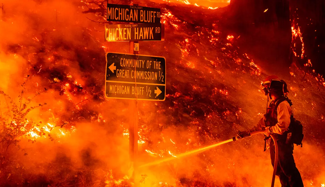Seorang petugas pemadam kebakaran memadamkan Mosquito Fire yang menyala dekat komunitas Michigan Bluff di Placer County, California, Amerika Serikat, 7 September 2022. (AP Photo/Noah Berger)