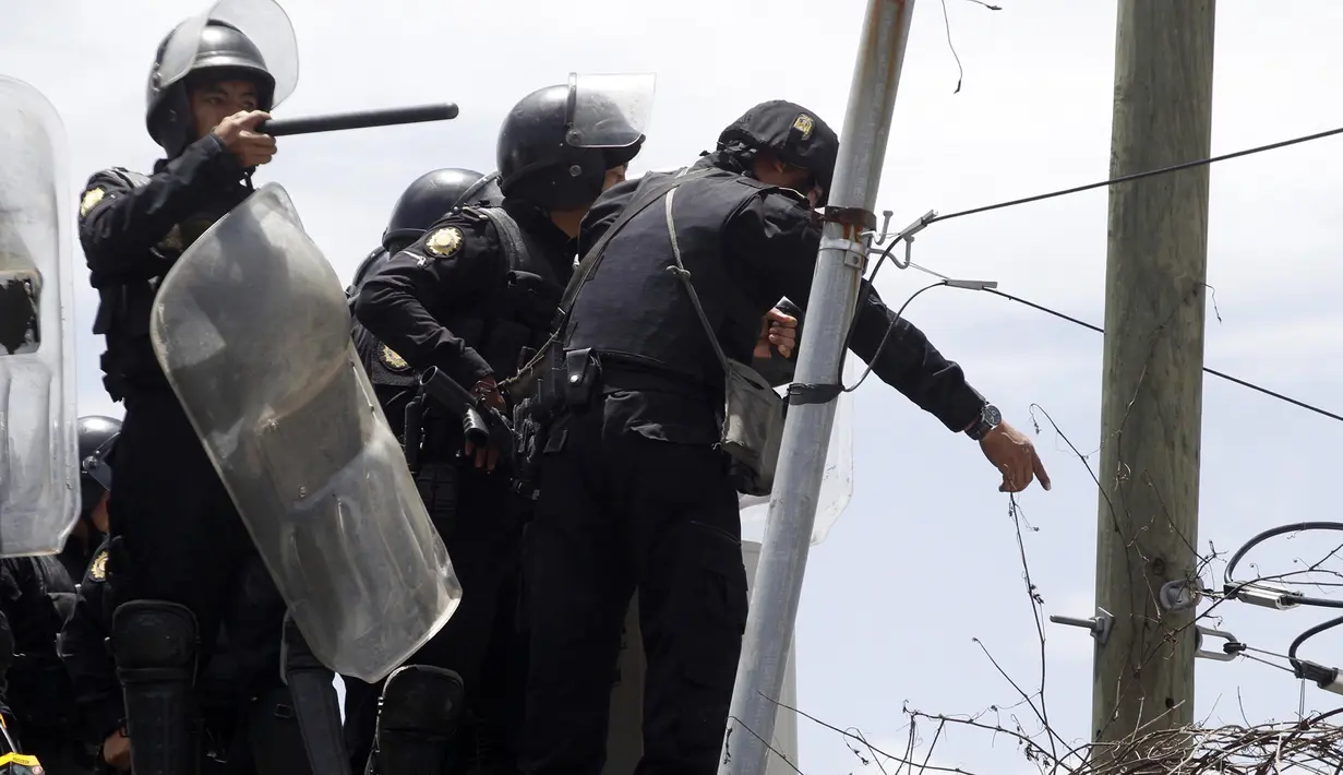 Petugas polisi berusaha meredam kerusuhan yang terjadi di penjara Juvenile Gaviotas di Guatemala City, Guatemala (3/7). Akibat kerusuhan tersebut, 10 narapidana remaja dilaporkan melarikan diri dari penjara. (AP Photo / Moises Castillo)