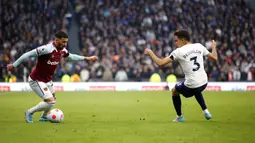 Pemain West Ham United Said Benrahma (kiri) berebut bola dengan pemain Tottenham Hotspur Sergio Reguilon pada pertandingan sepak bola Liga Inggris di Tottenham Hotspur Stadium, London, Inggris, Minggu (20/3/2022). Tottenham Hotspur menang 3-1. (AP Photo/David Cliff)