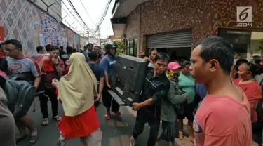 Warga berusaha menyelamatkan harta benda mereka ketika kebakaran melanda permukiman padat penduduk di Manggarai, Jakarta, Rabu (10/7/2019). Hingga saat ini sebanyak 28 unit mobil pemadam kebakaran dikerahkan di lokasi kejadian yang tak jauh dari Stasiun Kereta Api. (Liputan6.com/Herman Zakharia)