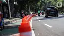 Kendaraan melintasi "stick cone" pembatas jalur sepeda di kawasan Pejompongan, Jakarta, Selasa (29/11/2022). Pemprov DKI Jakarta kembali mengganggarkan dana untuk perawatan jalur dan evaluasi pembatas sepeda pada rancangan APBD tahun anggaran 2023 sebesar Rp7,5 miliar setelah sebelumnya sempat dicoret dari anggaran dan menuai kecaman dari sejumlah pihak. (Liputan6.com/Johan Tallo)