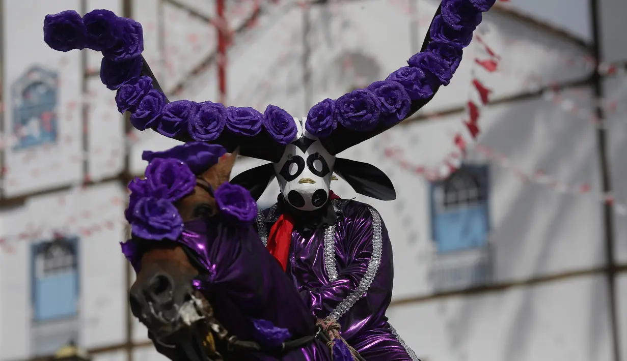 Seorang peserta mengenakan kostum menunggang kuda yang dihias saat mengikuti festival "Cavalhadas" di Pirenopolis, Brasil (20/5). Festival ini digelar selama tiga hari. (AP Photo/Eraldo Peres)