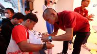 Pemain sayap Persija Jakarta, Riko Simanjuntak, membubuhkan tanda tangan untuk The Jakmania yang hadir di Rumah Indofood yang ada di JIExpo Kemayoran, Kamis (22/6/2023) petang WIB. (Bola.com/M. Iqbal Ichsan)