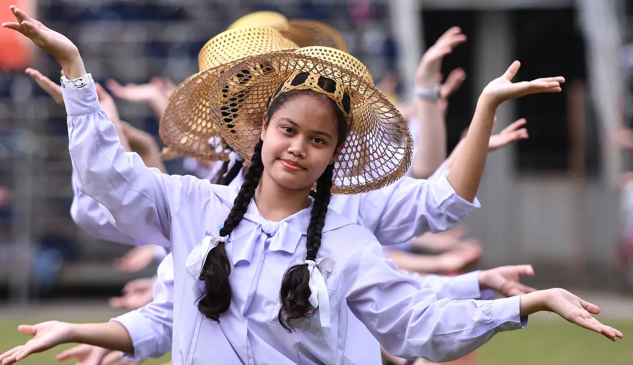Para pelajar menari saat mengikuti gladi resik di halaman sekolah di Bangkok, Thailand (13/11/2019). Gladi resik diadakan sebagai persiapan untuk kunjungan Paus Fransiskus yang  akan berada di Thailand pada 20-23 November 2019. (AFP Photo/Chalinee Thirasupa)