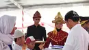 Presiden Jokowi menyerahkan Kartu Indonesia Pintar atau KIP secara simbolis kepada siswa di SMA Negeri 1 Palembang, Sumatra Selatan (22/1). (Liputan6.com/Pool/Biro Setpres)