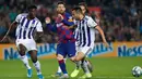 Megabintang Barcelona, Lionel Messi melakukan umpan silang dibayangi tiga pemain Real Valladolid dalam pertandingan pekan ke-11 La Liga  di Camp Nou, Selasa (29/10/2019). Barcelonamenutup laga dengan kemenangan 5-1 lewat gol tambahan dari Lionel Messi dan Luis Suarez. (AP/Joan Monfort)