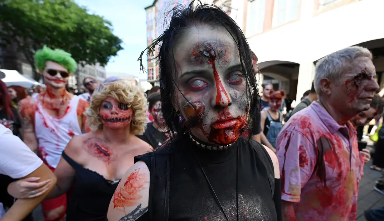 Seorang wanita memakai kostum dan berdandan menyerupai zombie saat mengambil bagian dalam acara Zombie Walk di kota Strasbourg, Prancis, 14 September 2019. Acara yang digelar dalam rangka Festival Film Fantasi Eropa ke-12 ini berlangsung dari  14 hingga 23 September. (FREDERICK FLORIN / AFP)