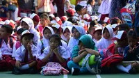 Murid-murid sekolah dasar duduk di halaman sekolah SDN 03, Pesanggrahan, Jakarta Selatan, Senin (16/7). Hari ini merupakan hari pertama masuk sekolah bagi para siswa dari jenjang TK hingga SMA untuk tahun ajaran 2018-2019. (Merdeka.com/Arie Basuki)