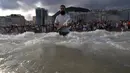 Seorang penganut kepercayaan Afro-Brasil membawa bunga sebagai persembahan untuk Dewi Laut, Yemanja dalam tradisi upacara menjelang tahun baru di pantai Copacabana, Rio de Janeiro, Sabtu (29/12). (AP/Leo Correa)