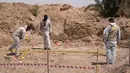 <p>Pakar forensik yang bekerja untuk otoritas Irak, menggali dan sejumlah sisa-sisa manusia ditemukan di kuburan massal dekat kota selatan Najaf, pada 14 Mei 2022. Kuburan massal itu, pertama kali ditemukan pada April tahun ini, diyakini menampung puluhan orang yang kemungkinan besar tewas di bawah mendiang diktator Saddam Hussein, kata seorang pejabat. (AFP)</p>
